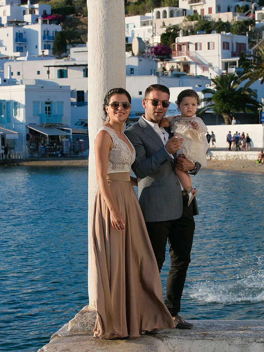 Mykonos waterfront family baptism portrait at golden hour in Greece