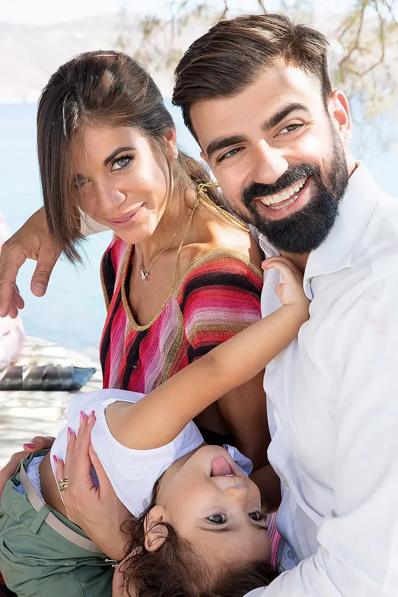 Sunlit family baptism portrait by the Mykonos coast in Greece