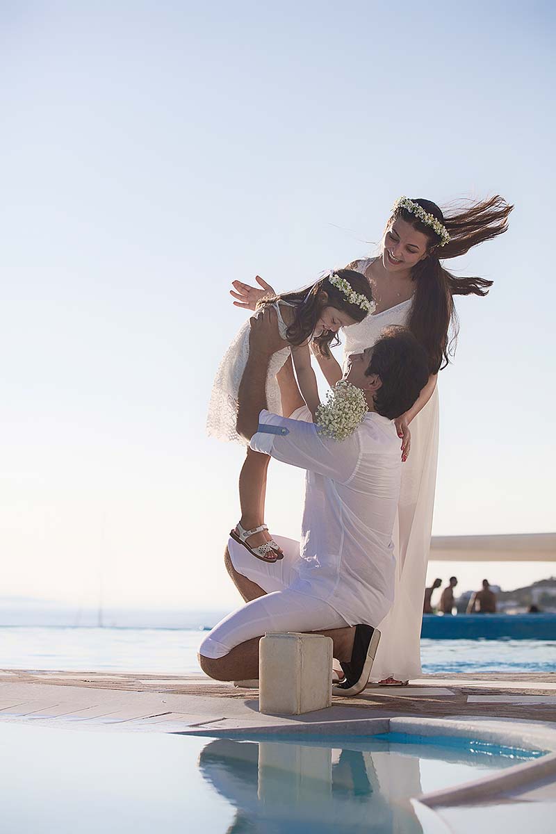 Family baptism portrait by infinity pool at sunset in Mykonos, Greece