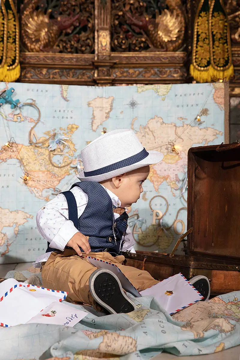 Adventure-themed baptism studio portrait with old suitcase in Mykonos, Greece