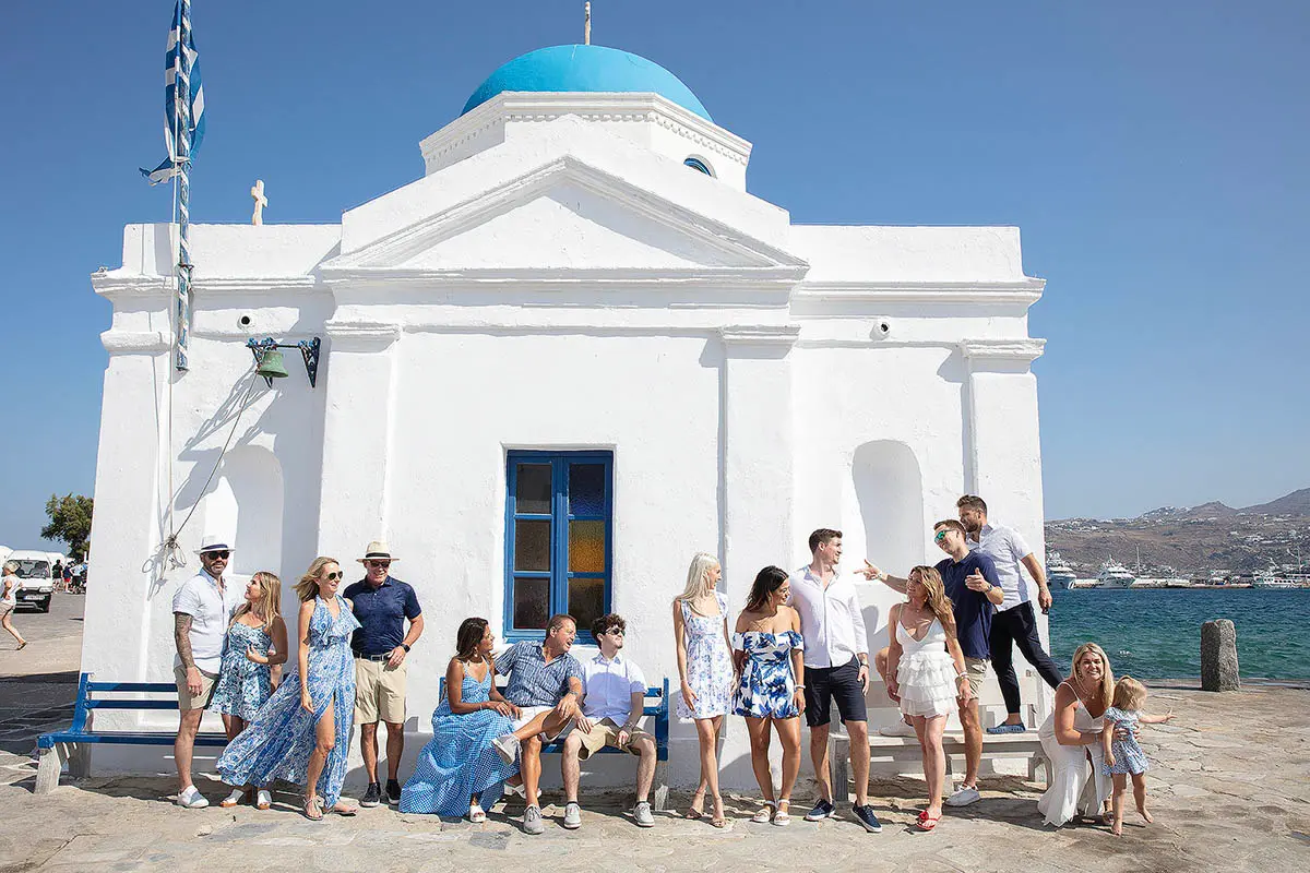 Joyful family children portrait by Mykonos blue doors in Greece