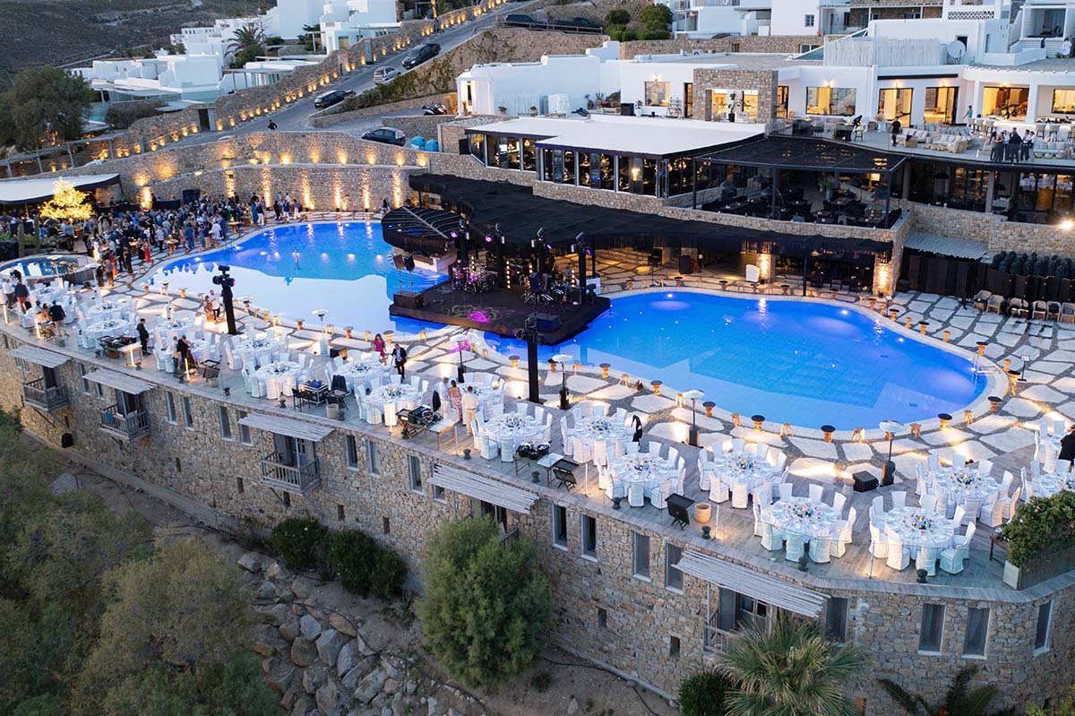 Aerial drone view of clifftop venue with twin pools in Mykonos, Greece