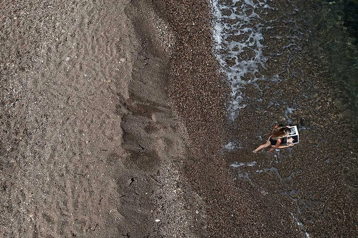 Aerial drone portrait on pebble beach in Mykonos, Greece