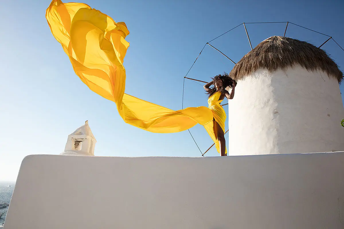 Sunlit cobalt flying dress in a Mykonos alley, photography in Mykonos, Greece