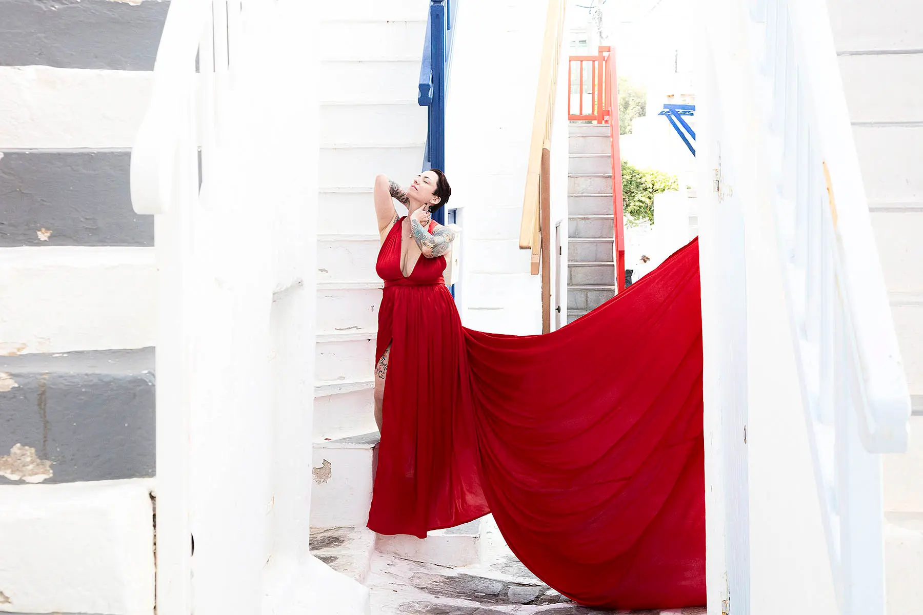 Sunlit cobalt flying dress near a whitewashed chapel, photography in Mykonos, Greece