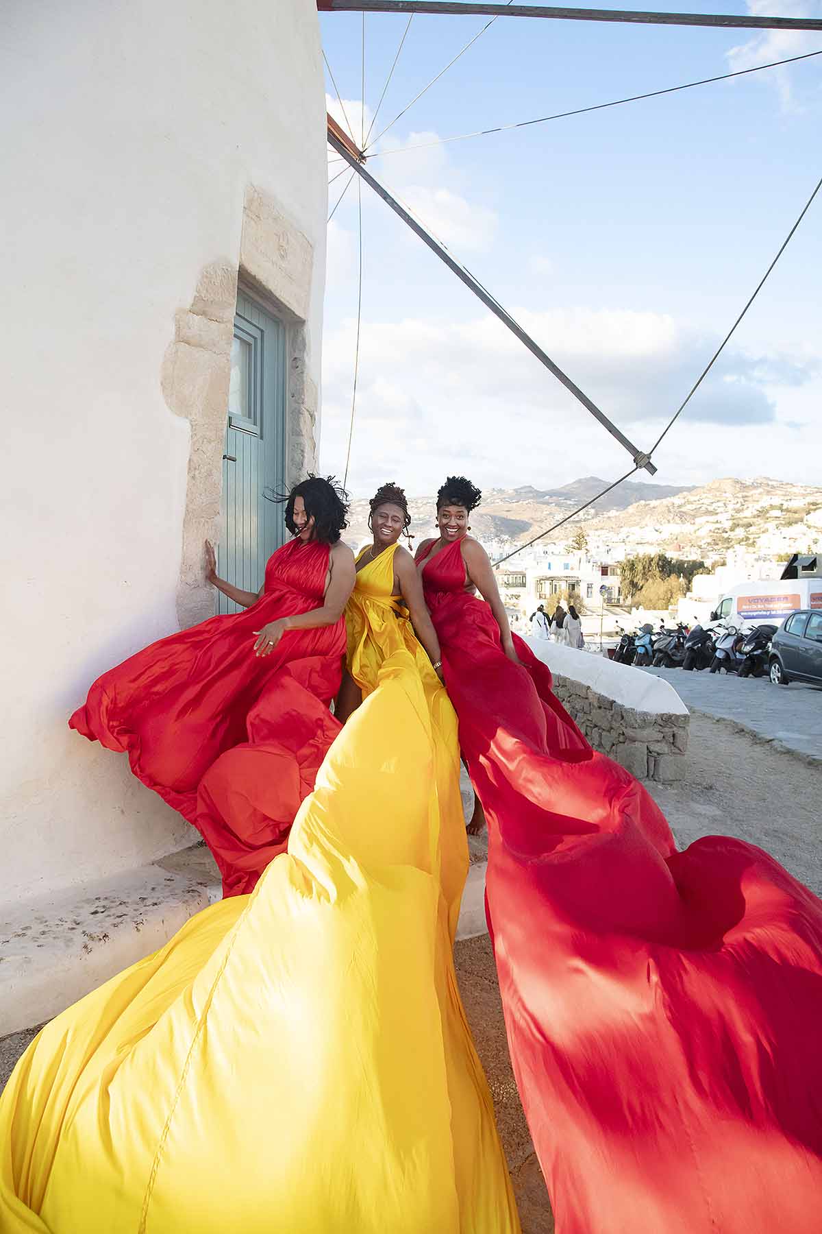 Sunlit dawn blush flying dress in a Mykonos alley, photography in Mykonos, Greece