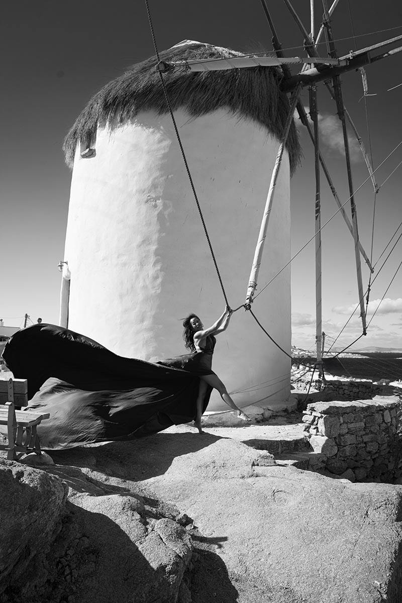 Sunlit dawn blush flying dress on a Mykonos rooftop, photography in Mykonos, Greece