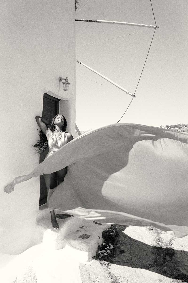 Sunlit dawn blush flying dress by the Aegean sea, photography in Mykonos, Greece