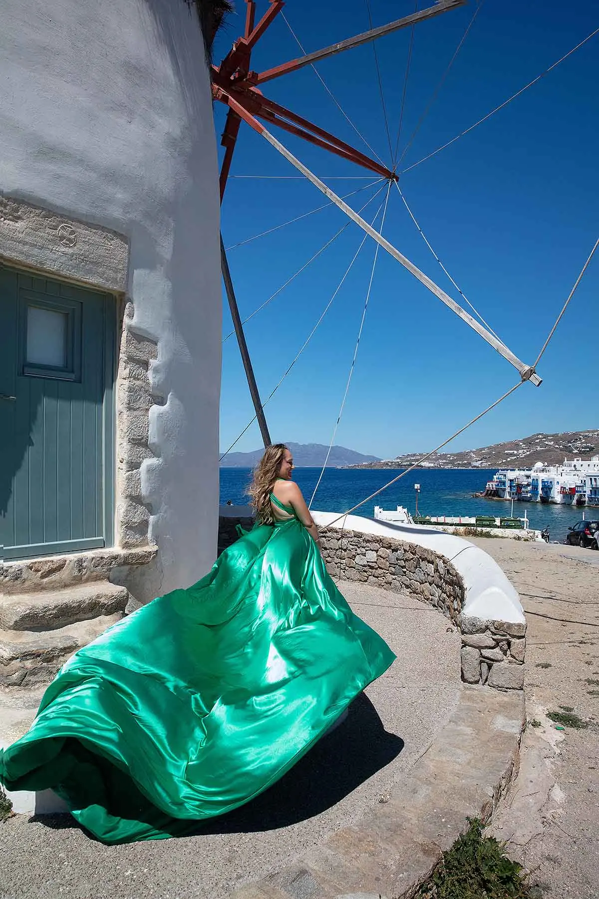 Sunlit emerald flying dress on a Mykonos rooftop, photography in Mykonos, Greece