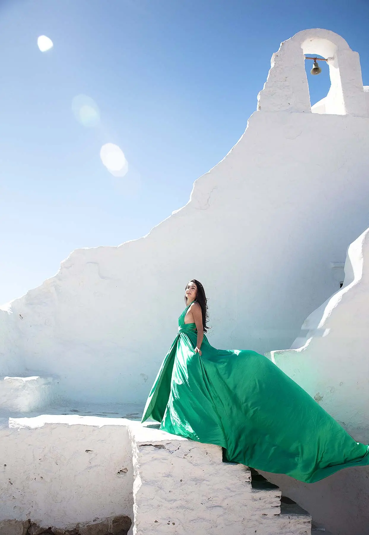 Sunlit emerald flying dress by the Aegean sea, photography in Mykonos, Greece