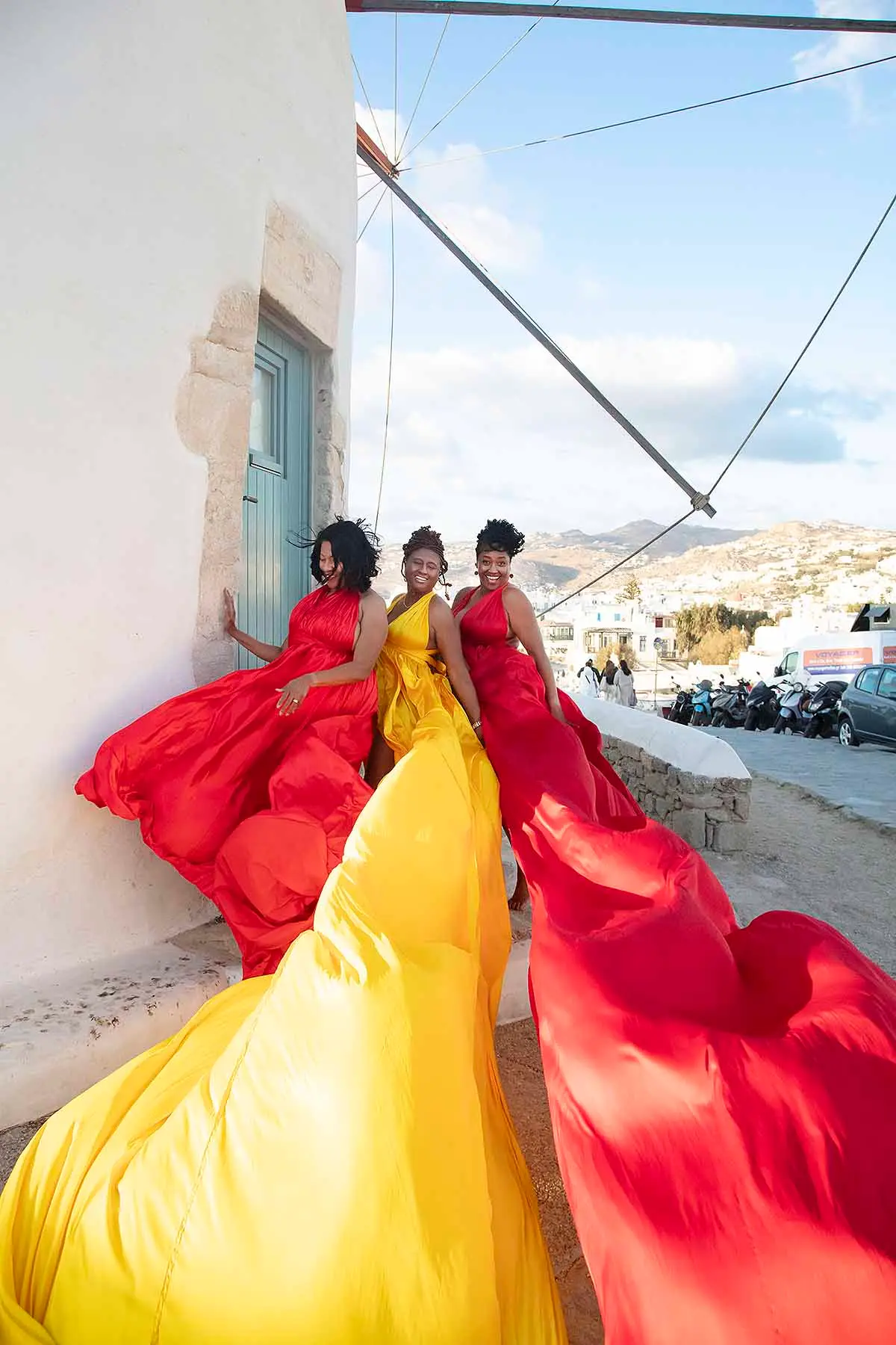 Sunlit emerald flying dress by Cycladic walls, photography in Mykonos, Greece