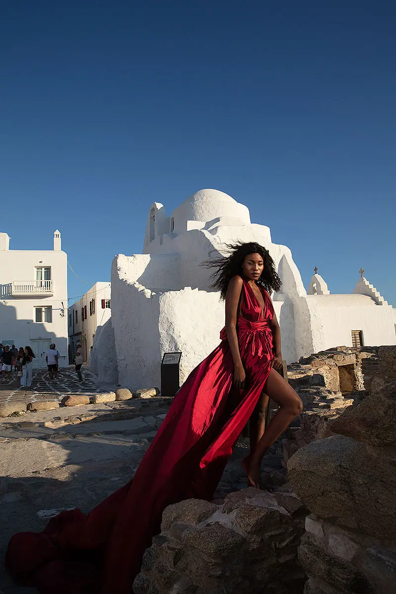 Sunlit gold flying dress by the Aegean sea, photography in Mykonos, Greece