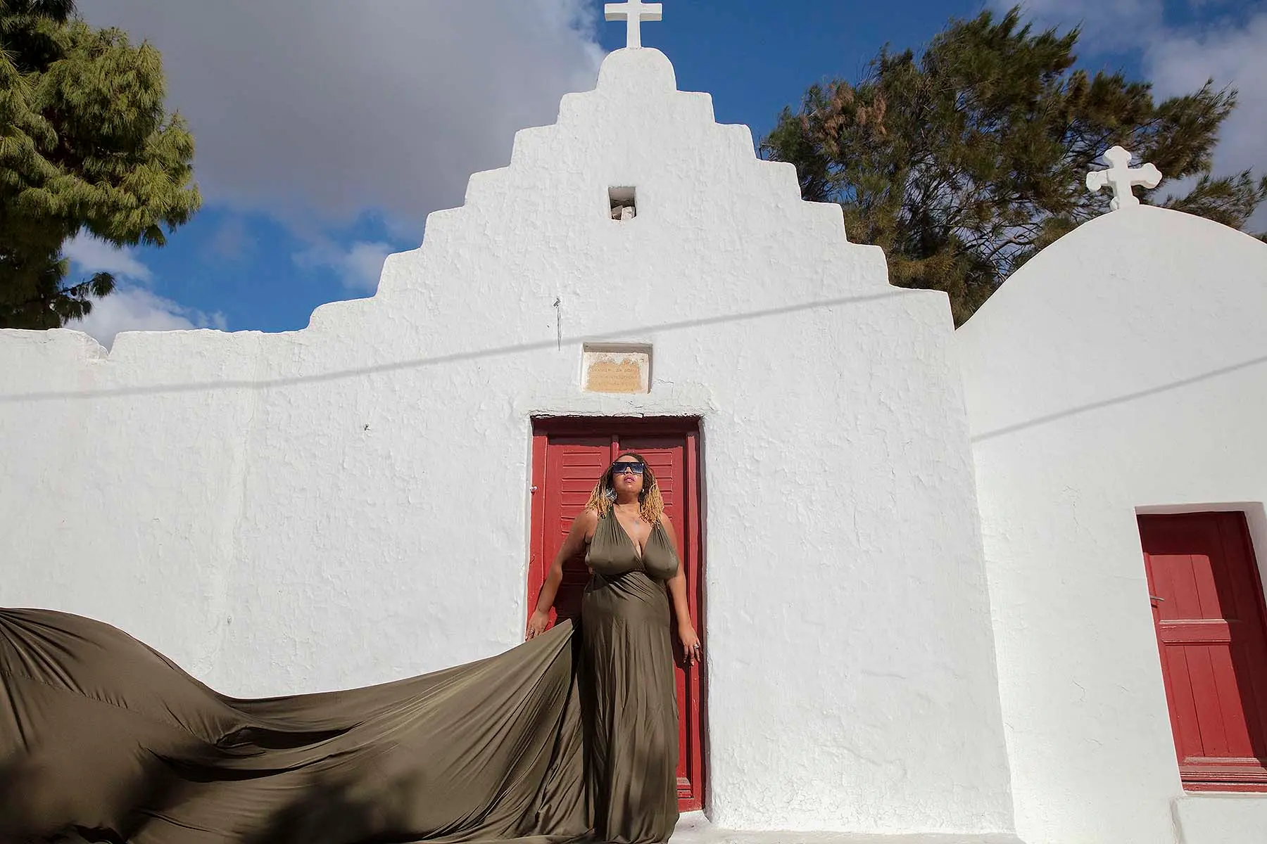 Sunlit gold flying dress by Cycladic walls, photography in Mykonos, Greece