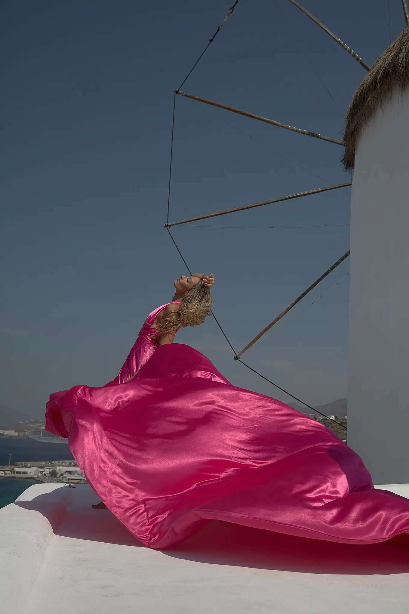 Sunlit indigo flying dress at a Mykonos windmill, photography in Mykonos, Greece