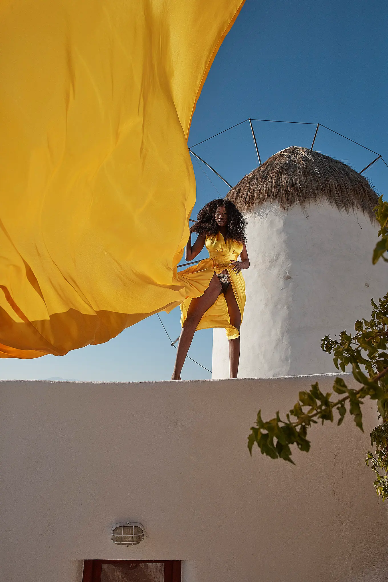 Sunlit indigo flying dress on a Mykonos rooftop, photography in Mykonos, Greece
