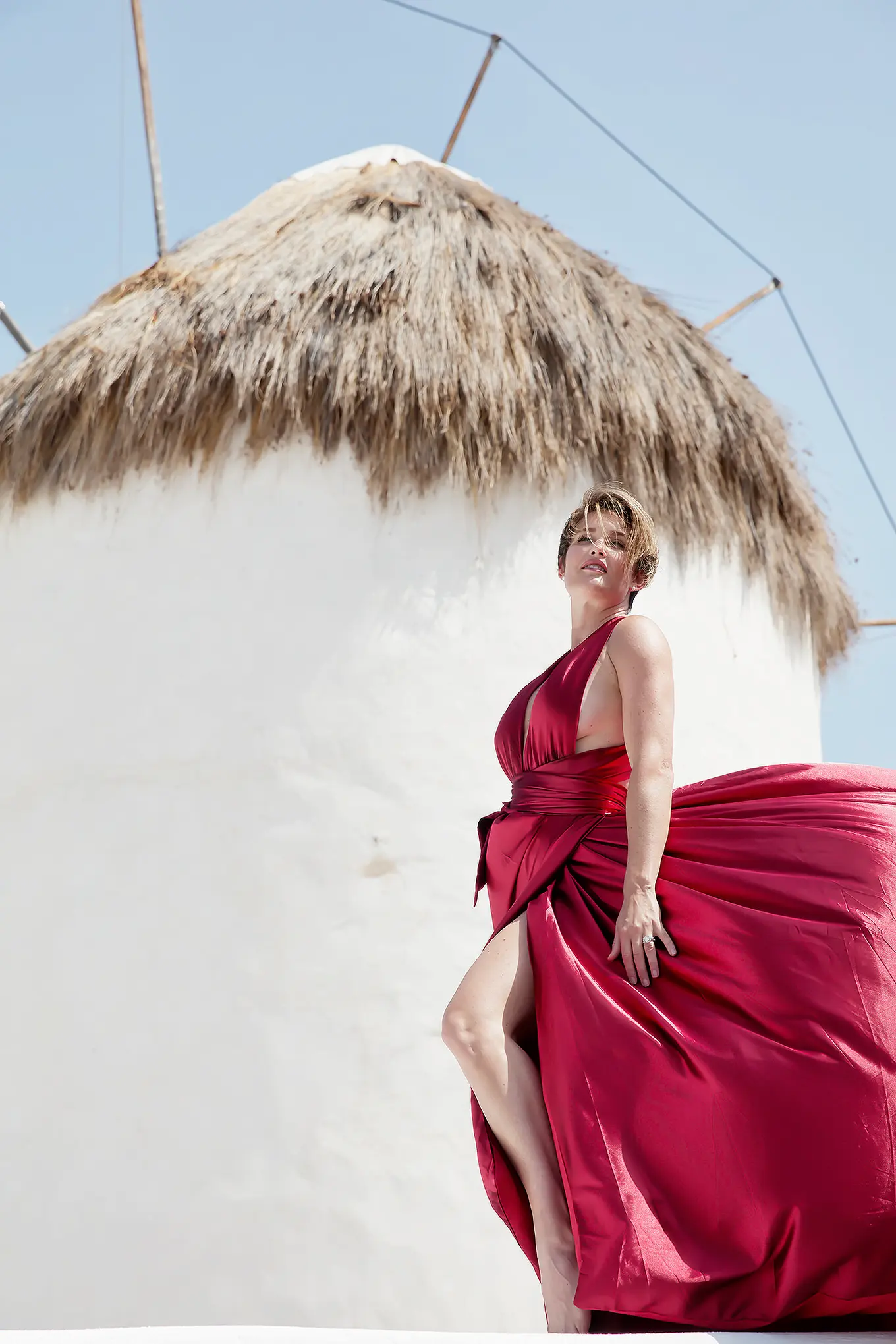 Sunlit indigo flying dress near a whitewashed chapel, photography in Mykonos, Greece