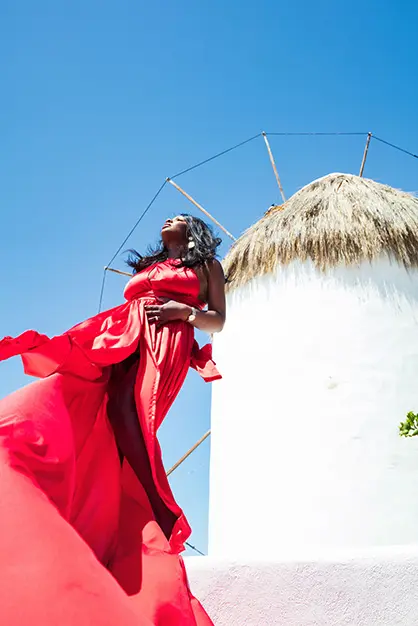 Sunlit ivory flying dress in a Mykonos alley, photography in Mykonos, Greece