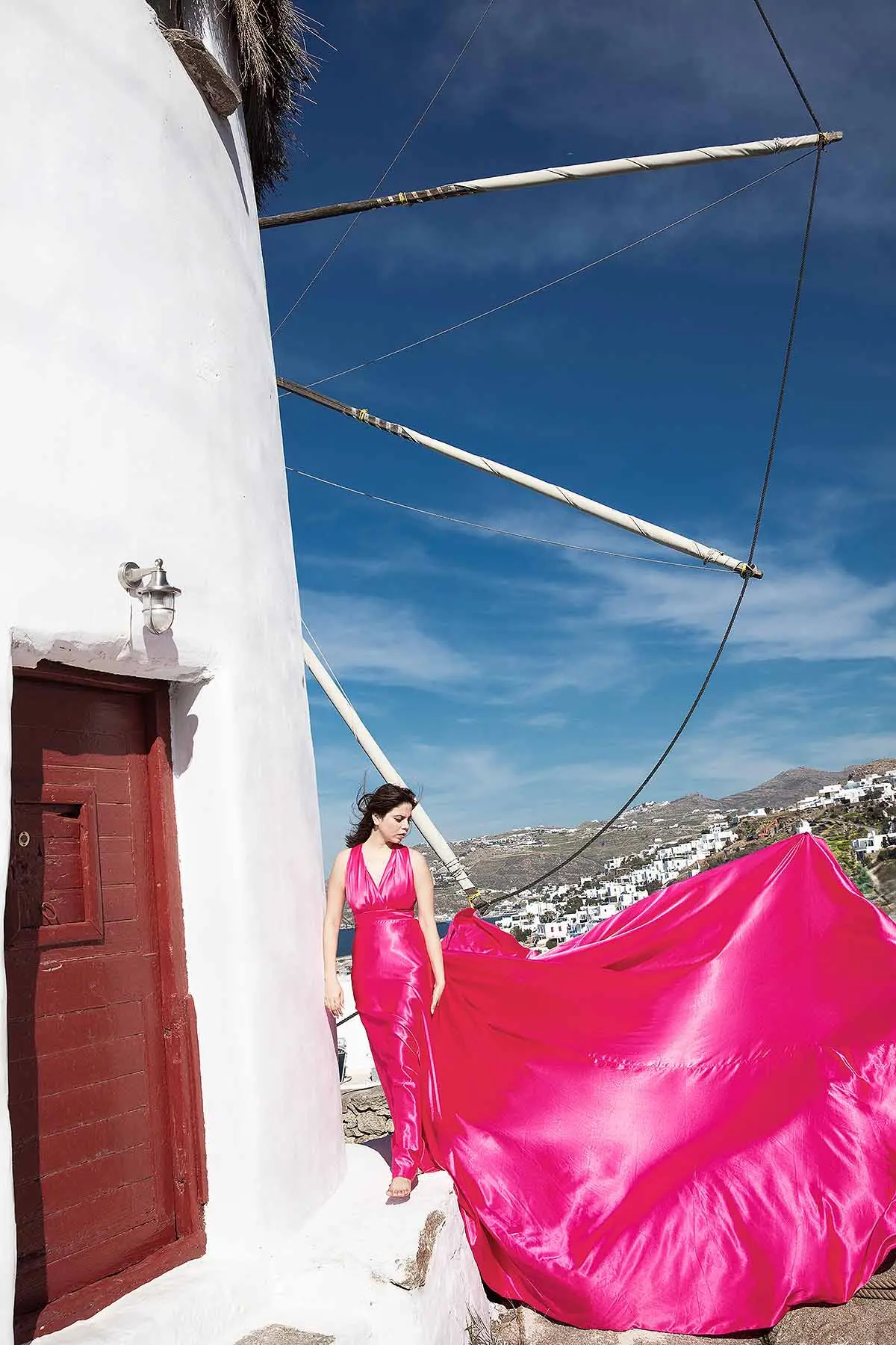 Sunlit ivory flying dress by the Aegean sea, photography in Mykonos, Greece