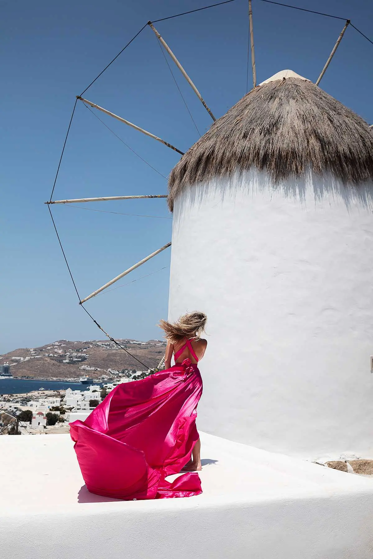 Sunlit ivory flying dress by Cycladic walls, photography in Mykonos, Greece