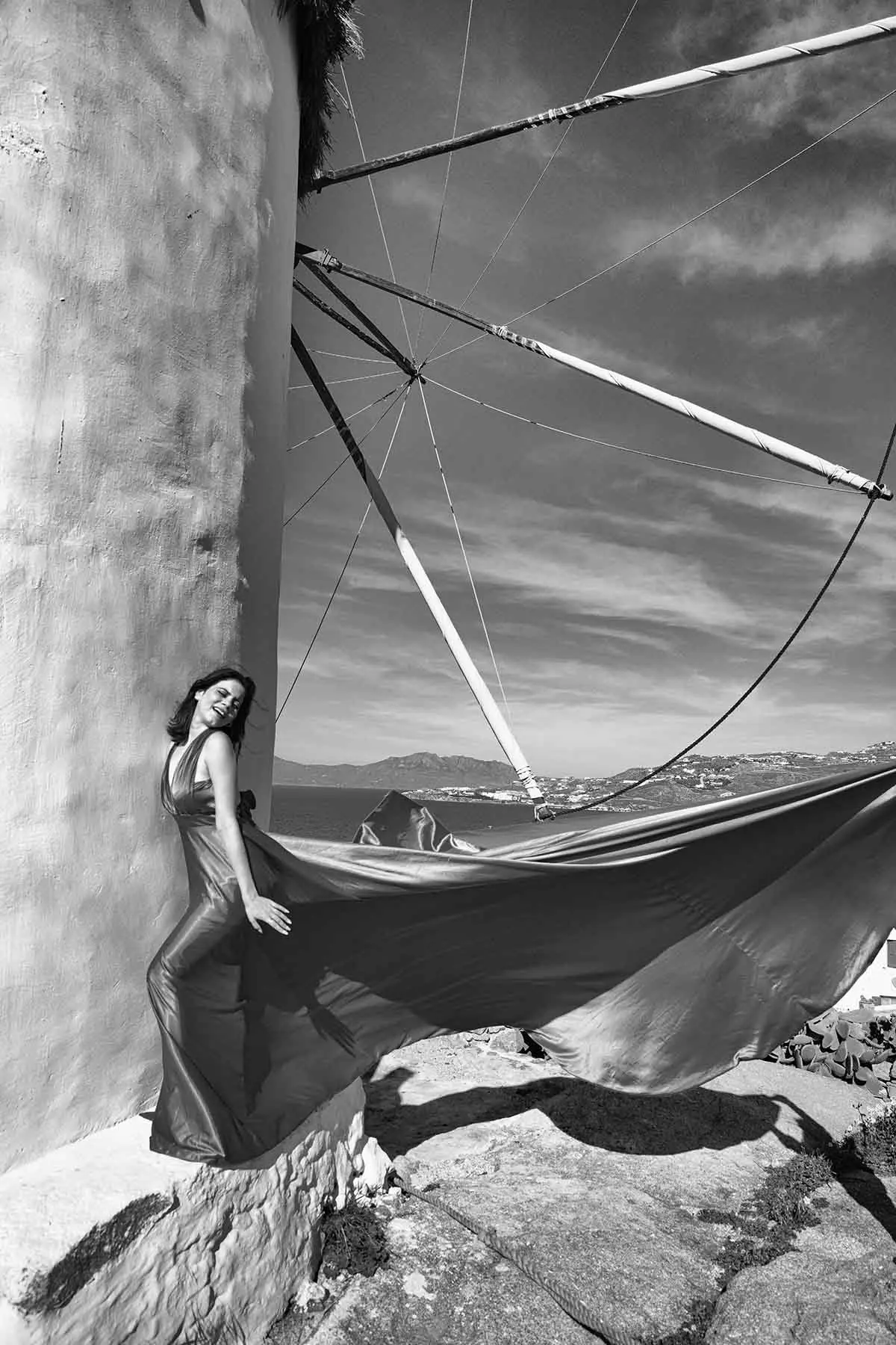 Sunlit ivory flying dress near a whitewashed chapel, photography in Mykonos, Greece