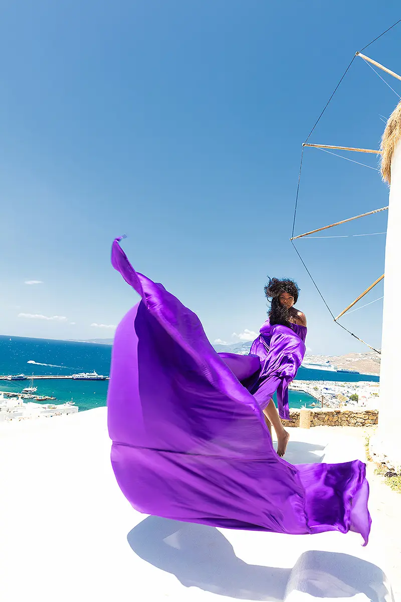 Sunlit magenta flying dress on a Mykonos rooftop, photography in Mykonos, Greece