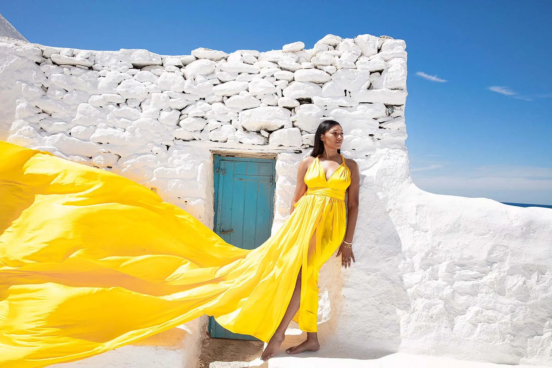 Sunlit magenta flying dress by the Aegean sea, photography in Mykonos, Greece