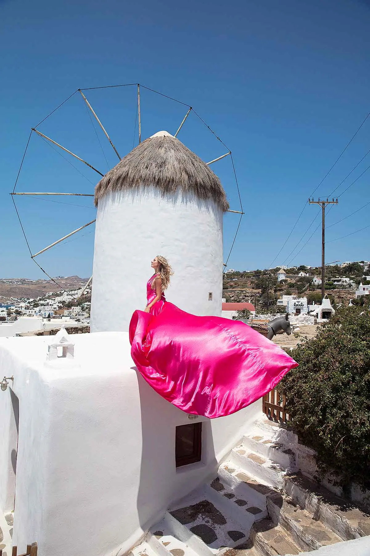 Sunlit noir alley flying dress in a Mykonos alley, photography in Mykonos, Greece