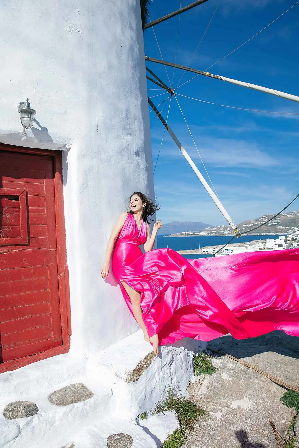 Sunlit noir alley flying dress on a Mykonos rooftop, photography in Mykonos, Greece