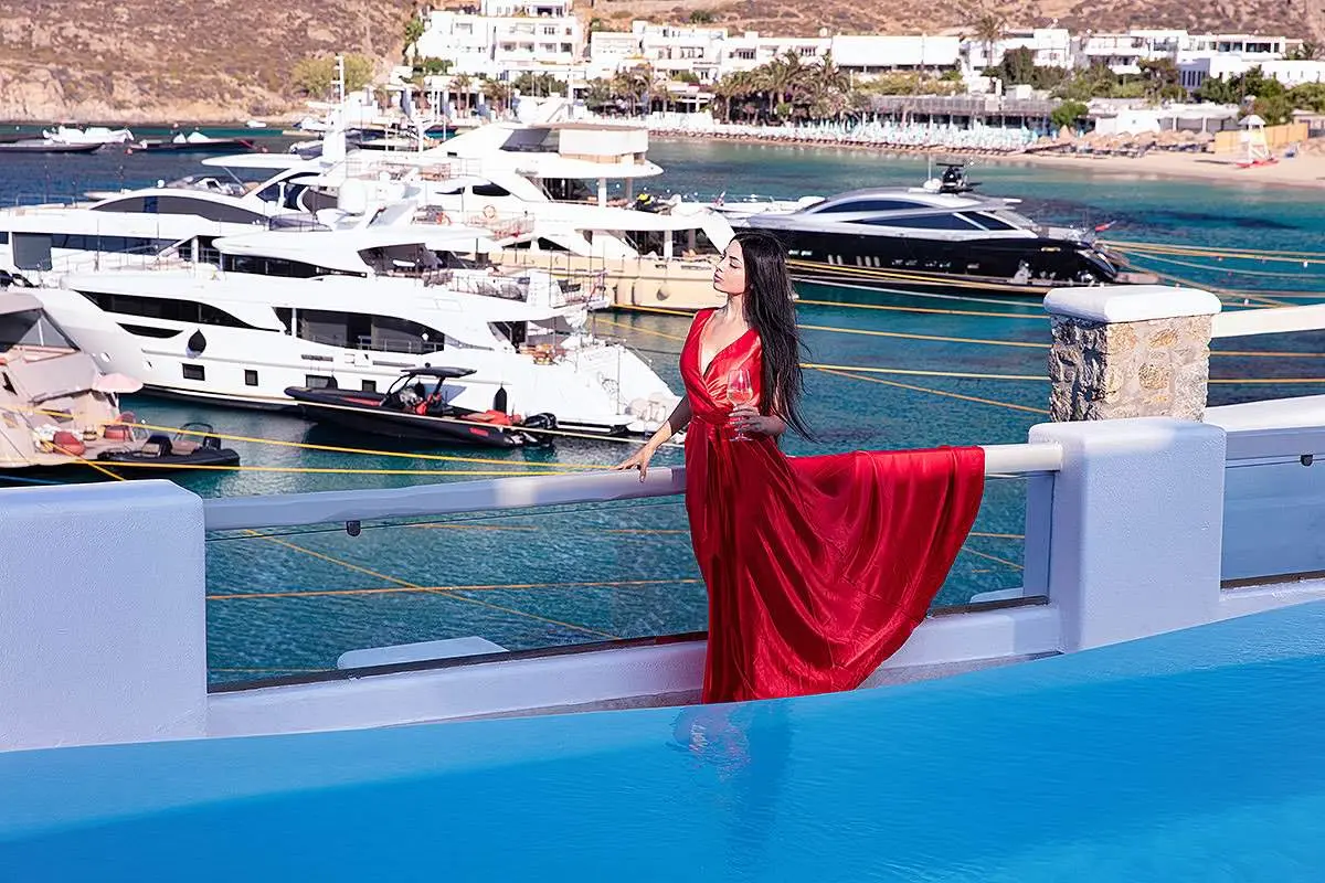 Sunlit pearl flying dress near a whitewashed chapel, photography in Mykonos, Greece
