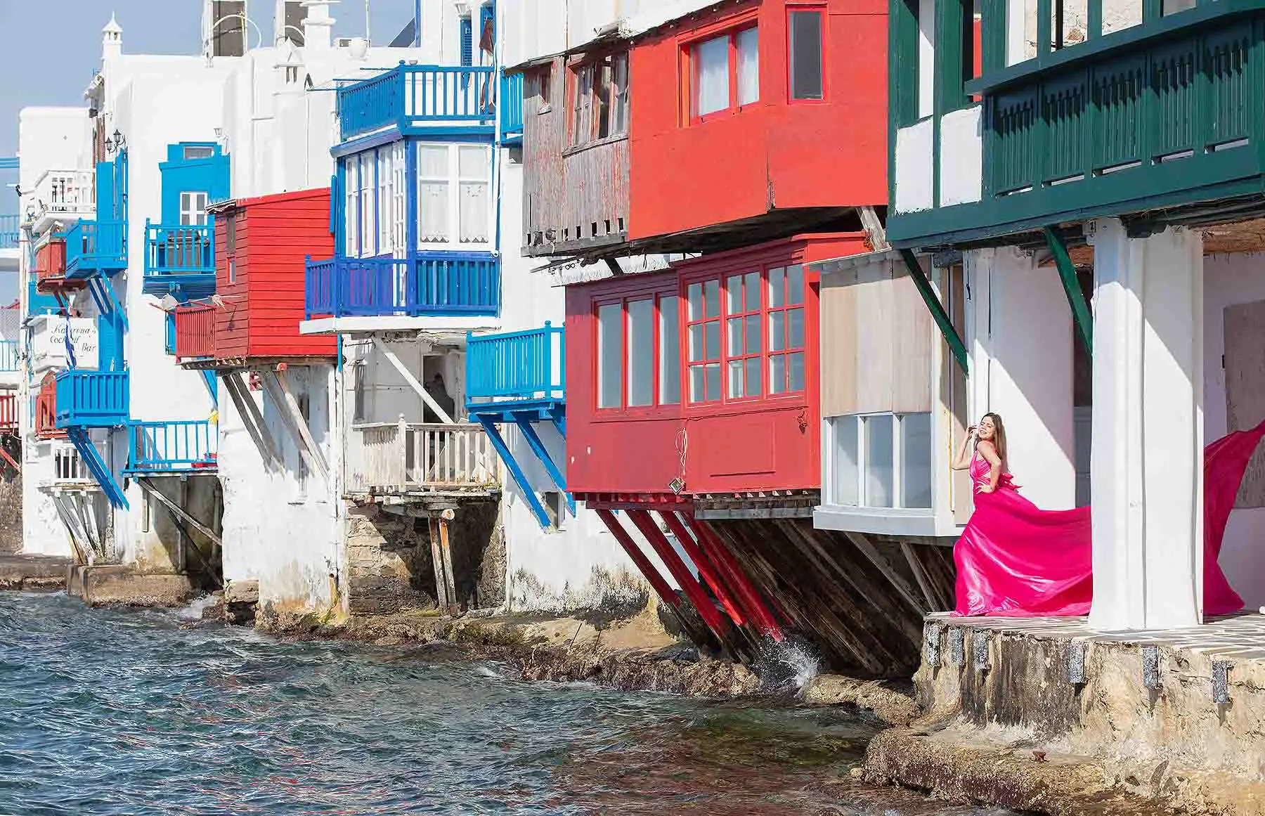 Sunlit rose flying dress on a Mykonos rooftop, photography in Mykonos, Greece