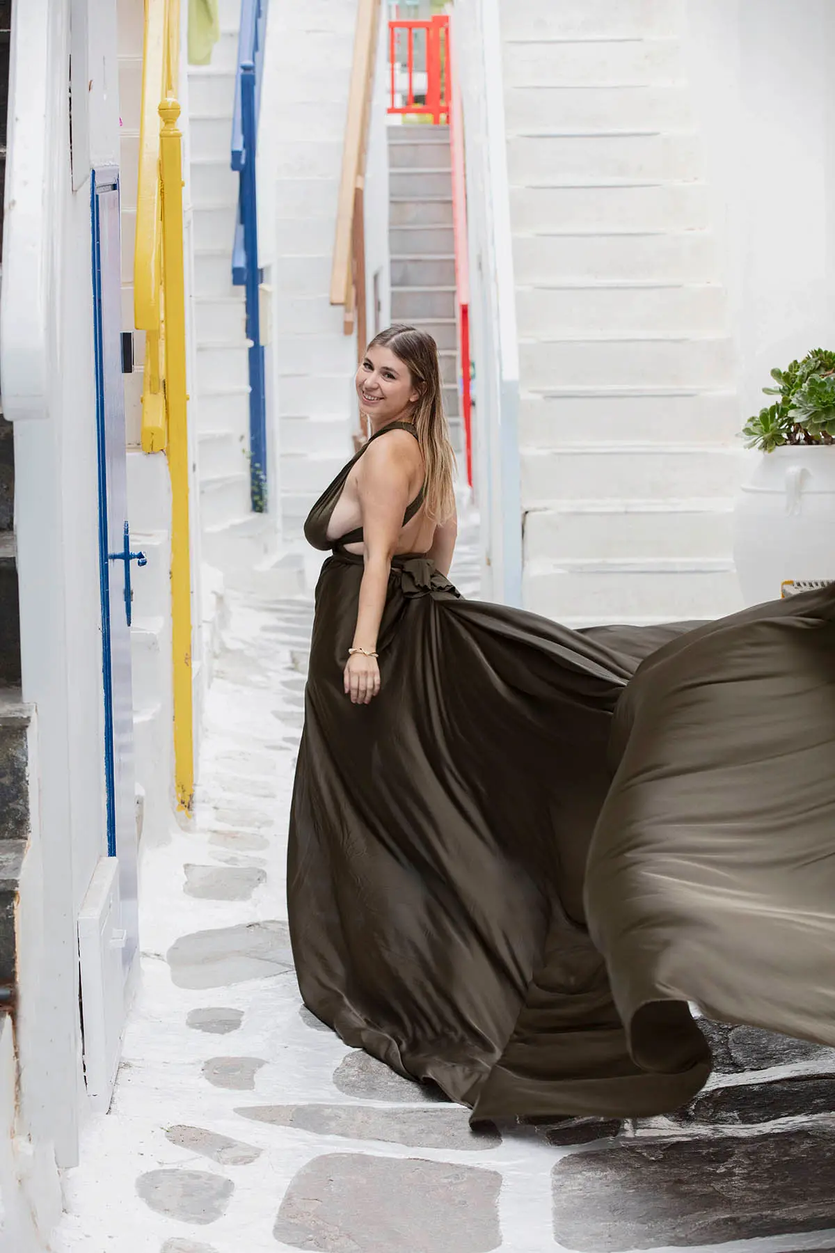 Sunlit rose flying dress by Cycladic walls, photography in Mykonos, Greece