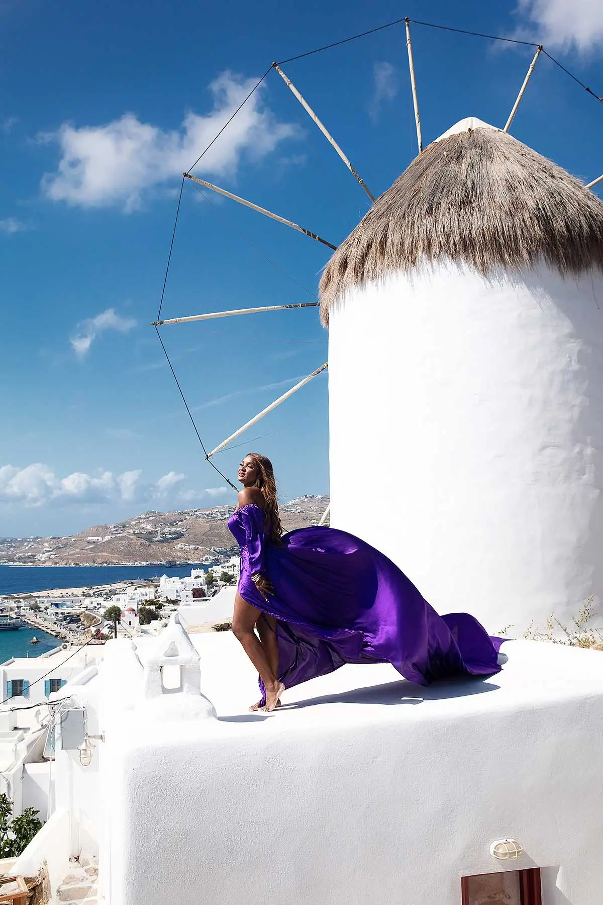 Sunlit sapphire flying dress on a Mykonos rooftop, photography in Mykonos, Greece