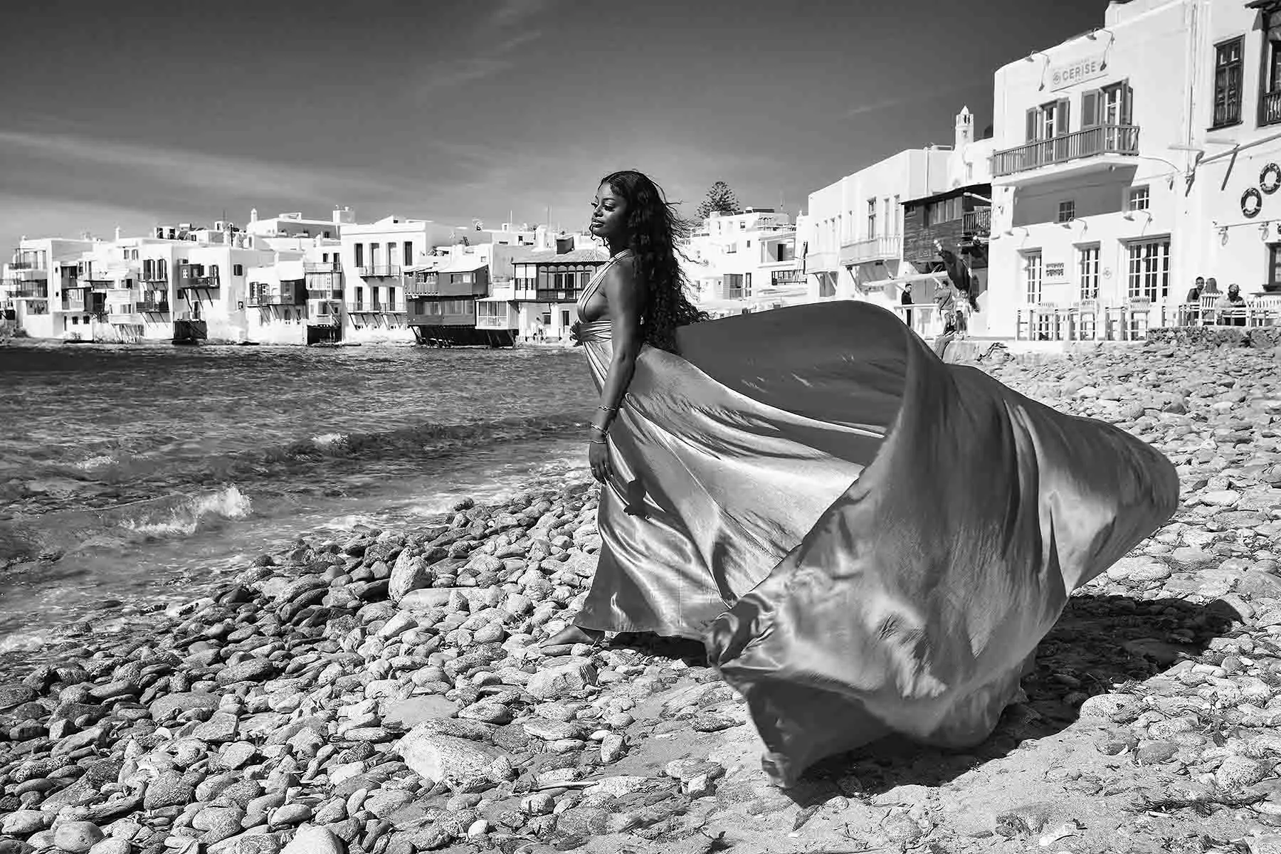 Sunlit sapphire flying dress by the Aegean sea, photography in Mykonos, Greece