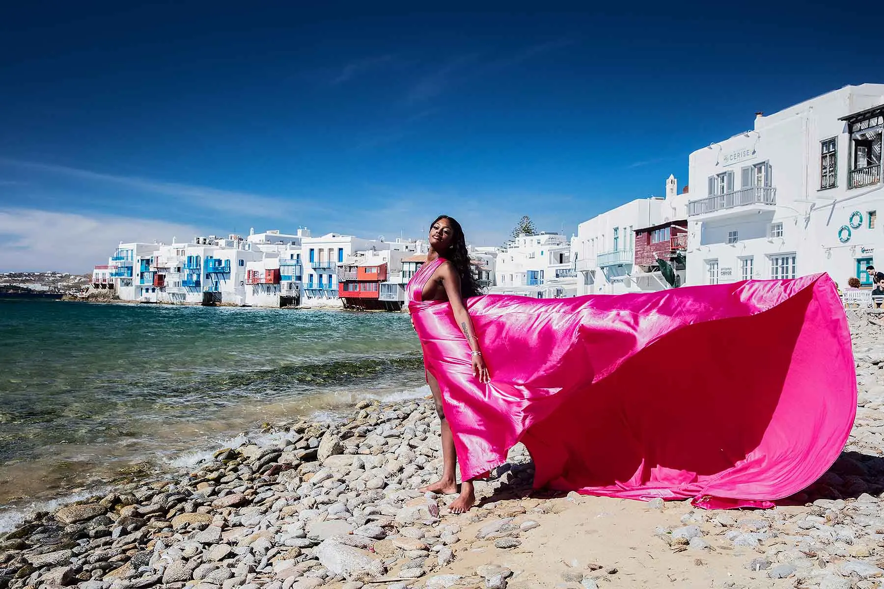 Sunlit sapphire flying dress on a sunlit terrace, photography in Mykonos, Greece