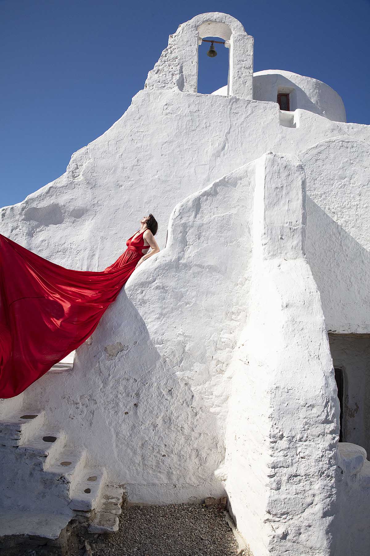 Sunlit sunset flying dress at a Mykonos windmill, photography in Mykonos, Greece