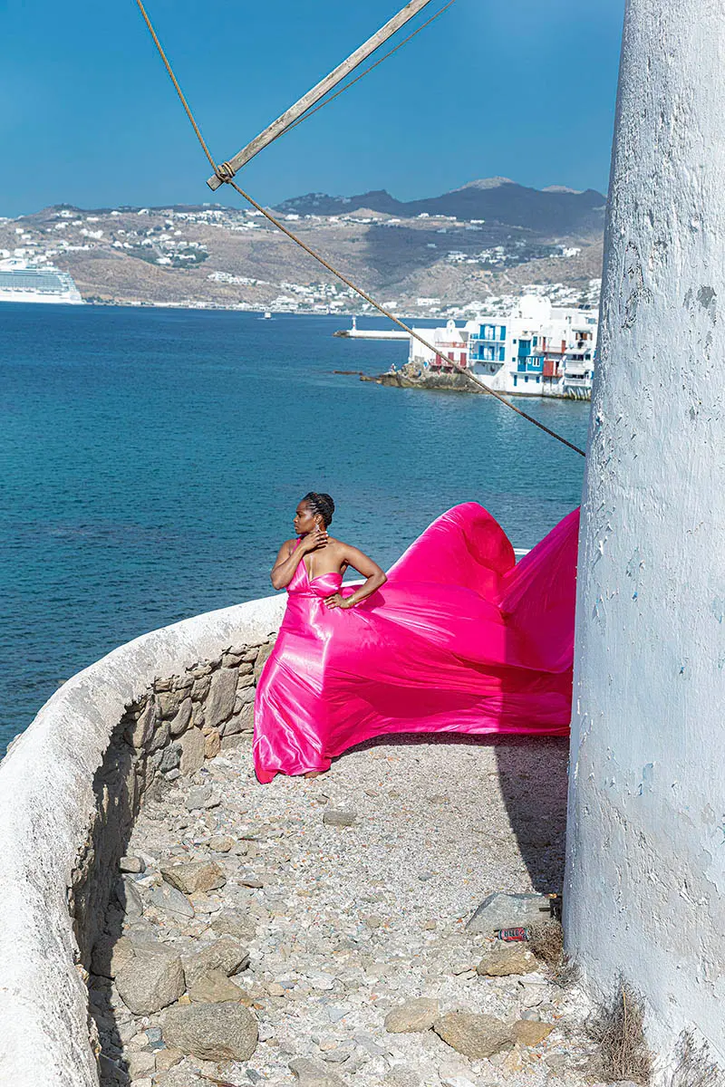 Sunlit teal flying dress on a sunlit terrace, photography in Mykonos, Greece