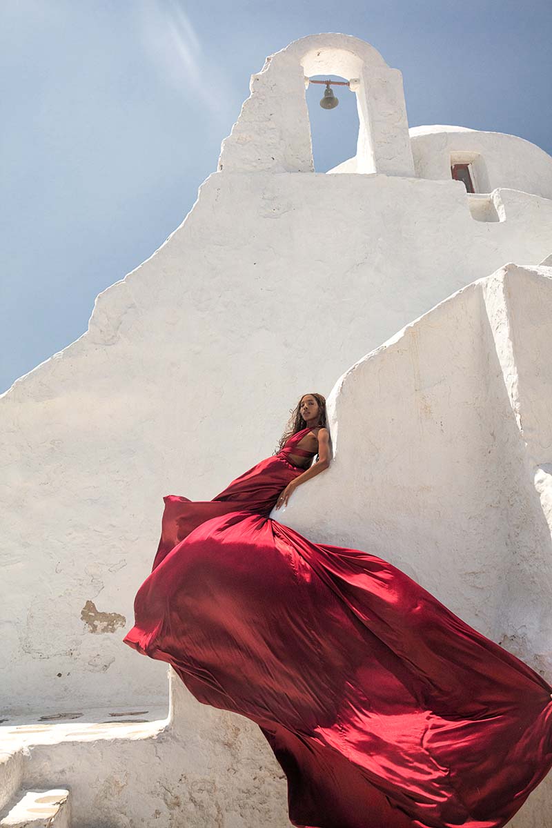 Sunlit twilight flying dress at a Mykonos windmill, photography in Mykonos, Greece