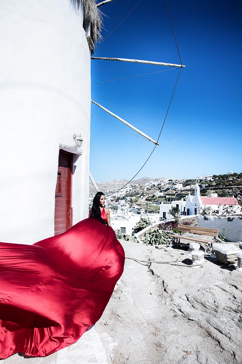 Sunlit twilight flying dress by Cycladic walls, photography in Mykonos, Greece
