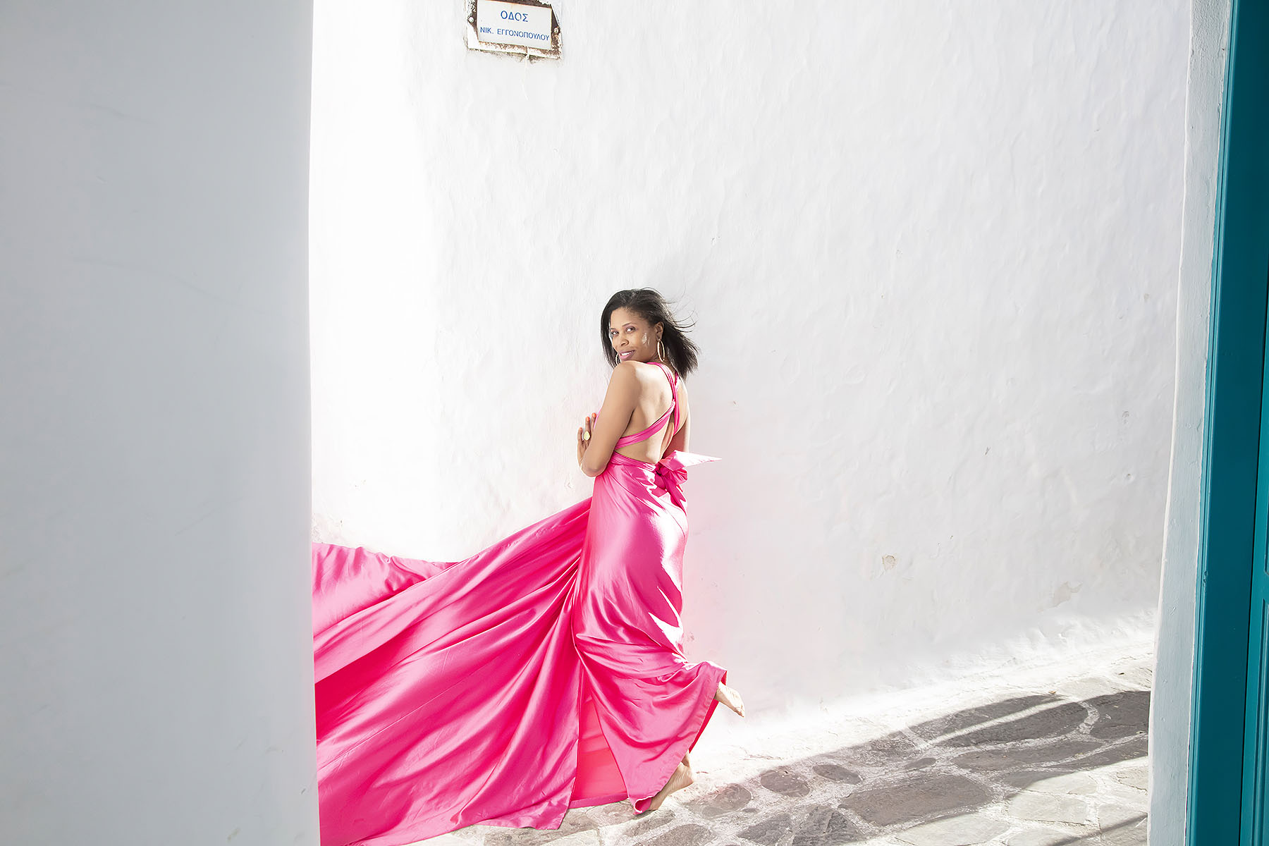 Sunlit twilight flying dress near a whitewashed chapel, photography in Mykonos, Greece