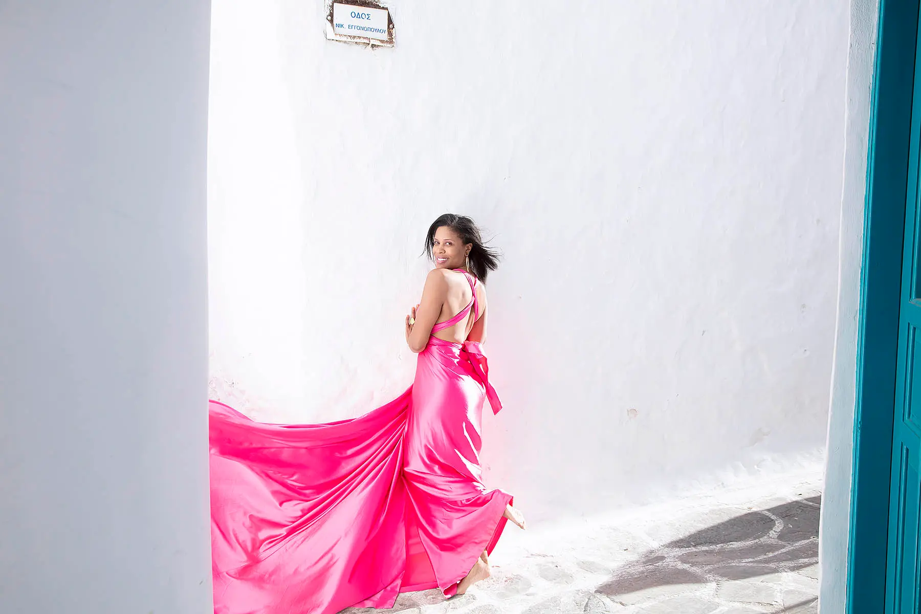Sunlit violet flying dress in a Mykonos alley, photography in Mykonos, Greece