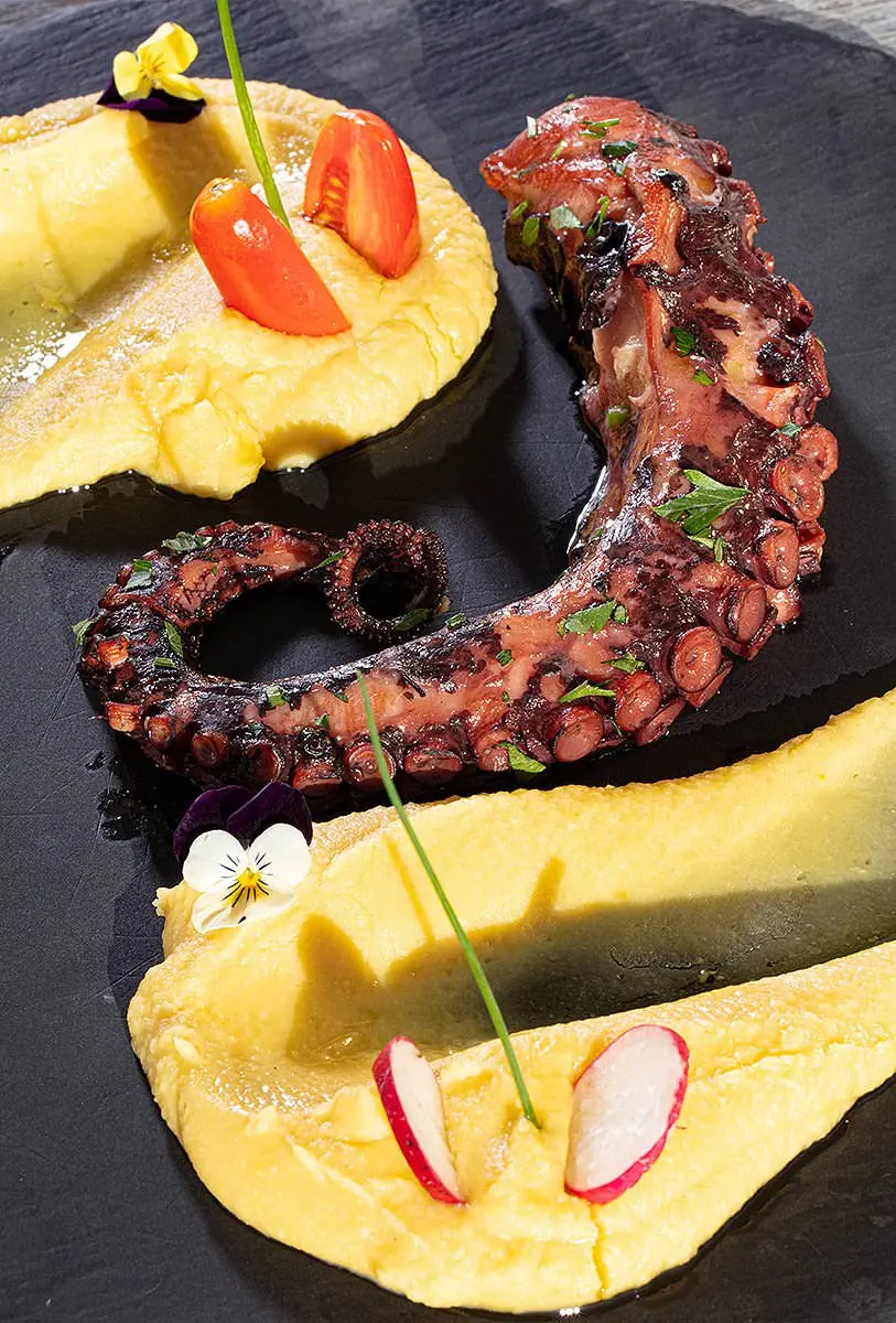 Octopus tentacle styled on slate, still life food photography in Mykonos, Greece