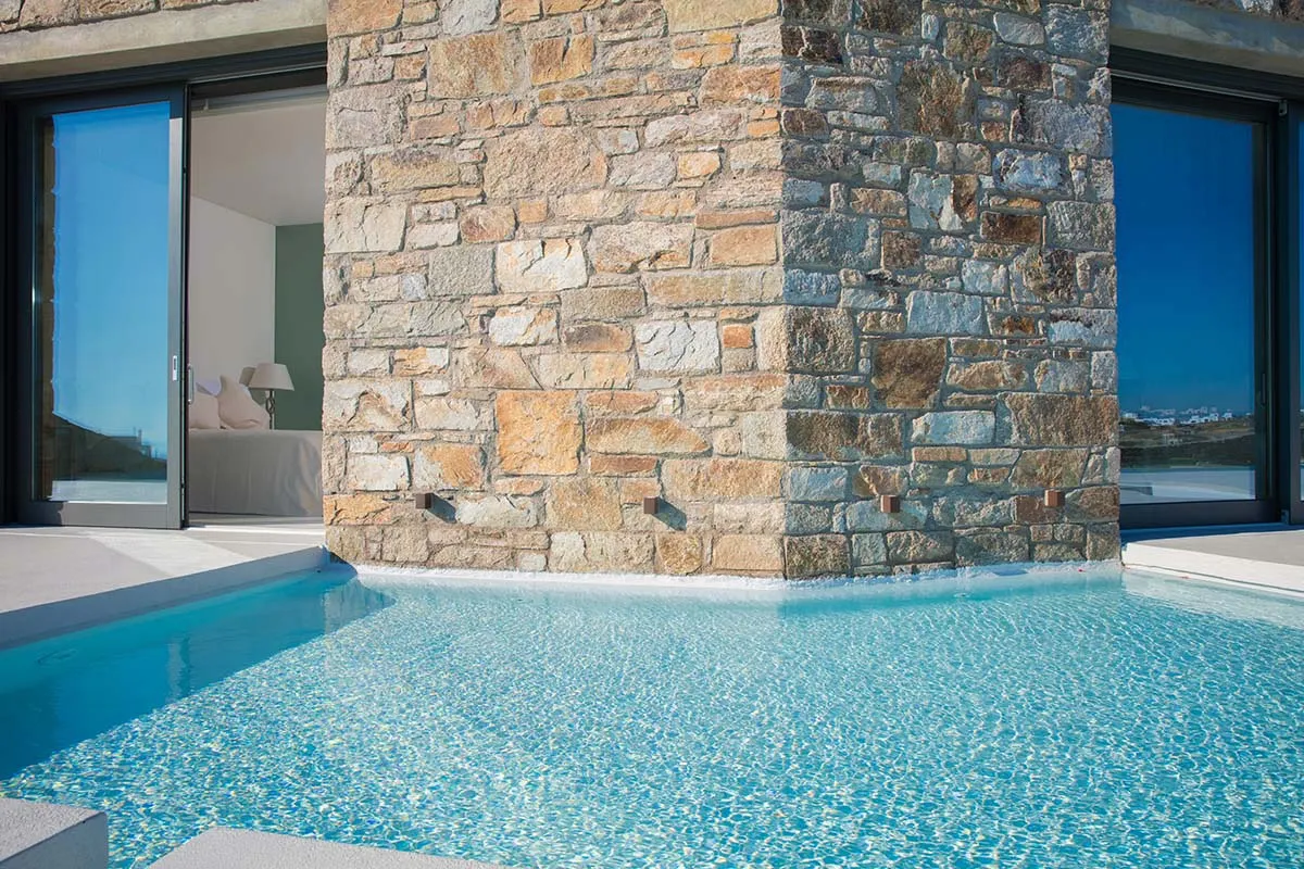 Sunlit beachfront hotels villas advertising moment in Mykonos, Greece