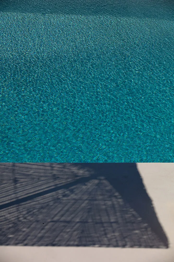 Sunlit infinity pool hotels villas advertising view in Mykonos, Greece