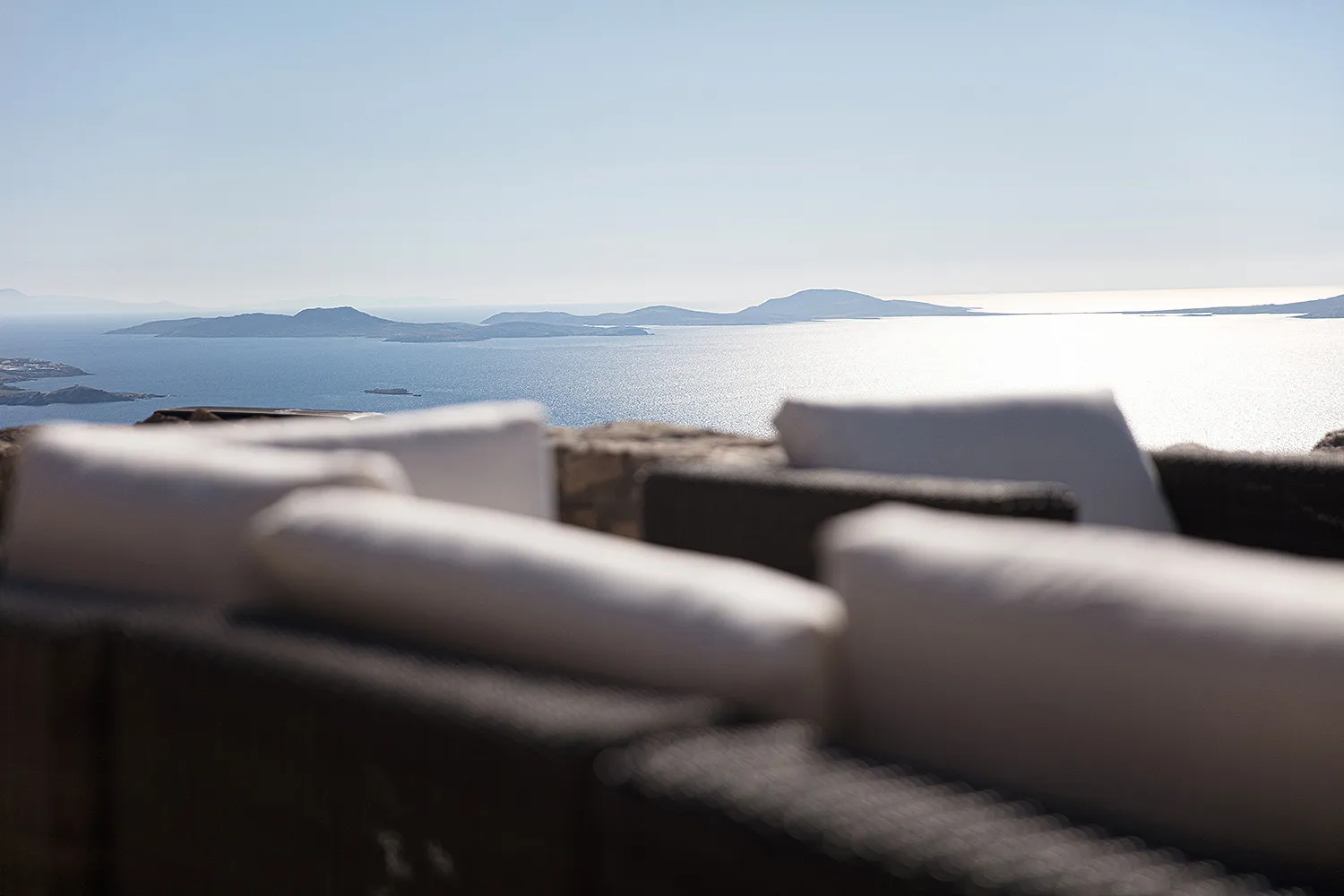 Sunlit infinity pool hotels villas advertising study in Mykonos, Greece