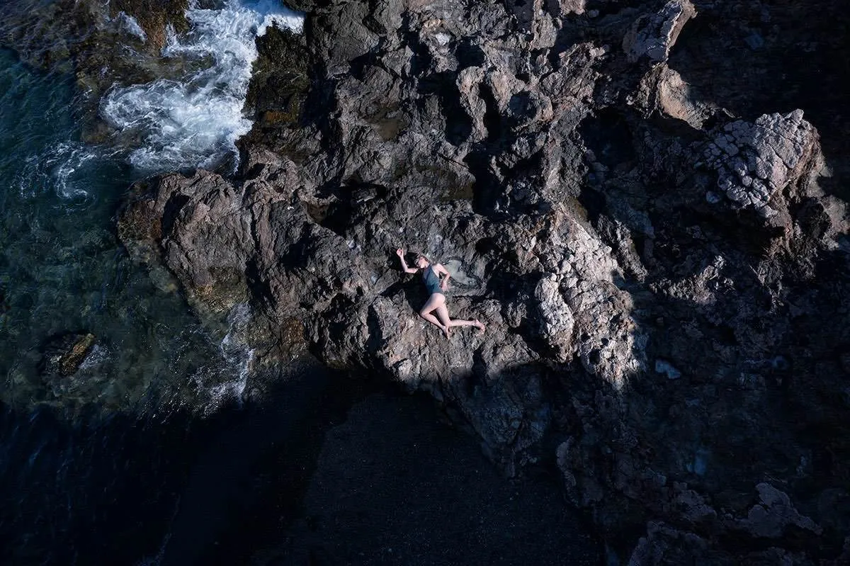 Soft-light aerial swimmer portrait frame in Mykonos, Greece