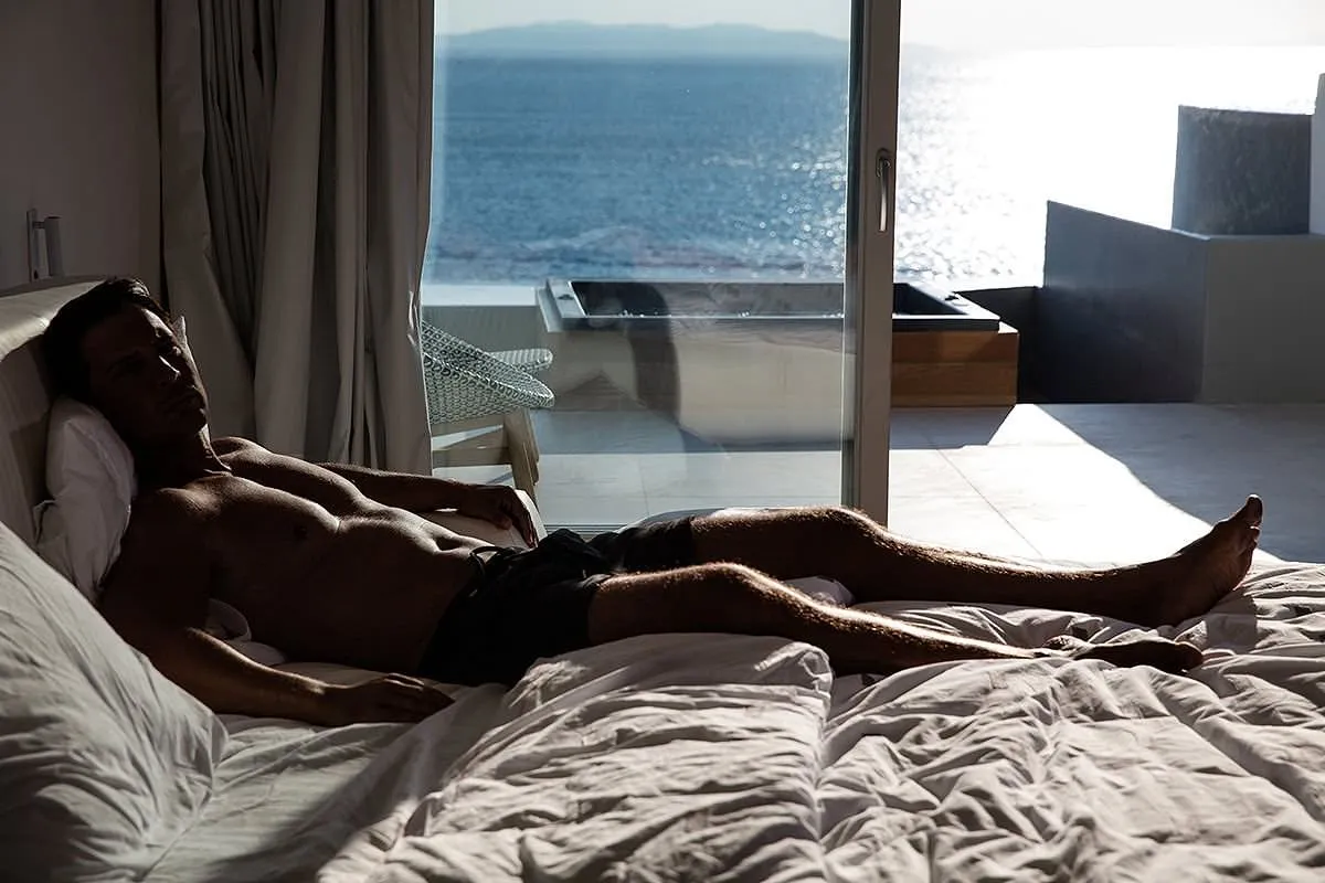 Soft-light male infinity pool portrait view in Mykonos, Greece