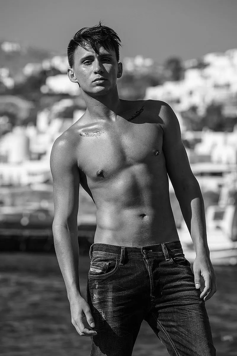 Soft-light monochrome male harbor portrait frame in Mykonos, Greece