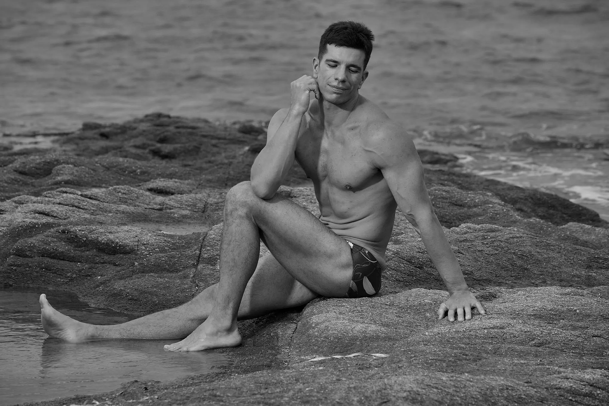 Soft-light monochrome male rocks portrait frame in Mykonos, Greece
