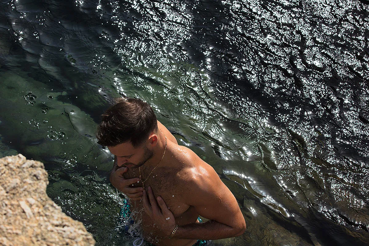Soft-light rock pool male portrait frame in Mykonos, Greece