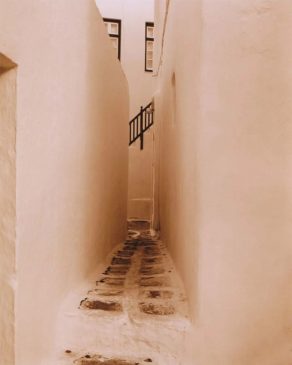 Sepia toned narrow Mykonos alley travel photography in Greece